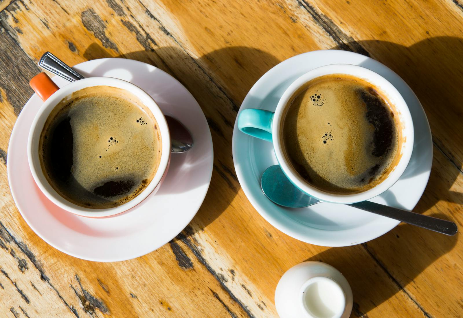 Two flat white coffees on a wooden table in a Melbourne cafe