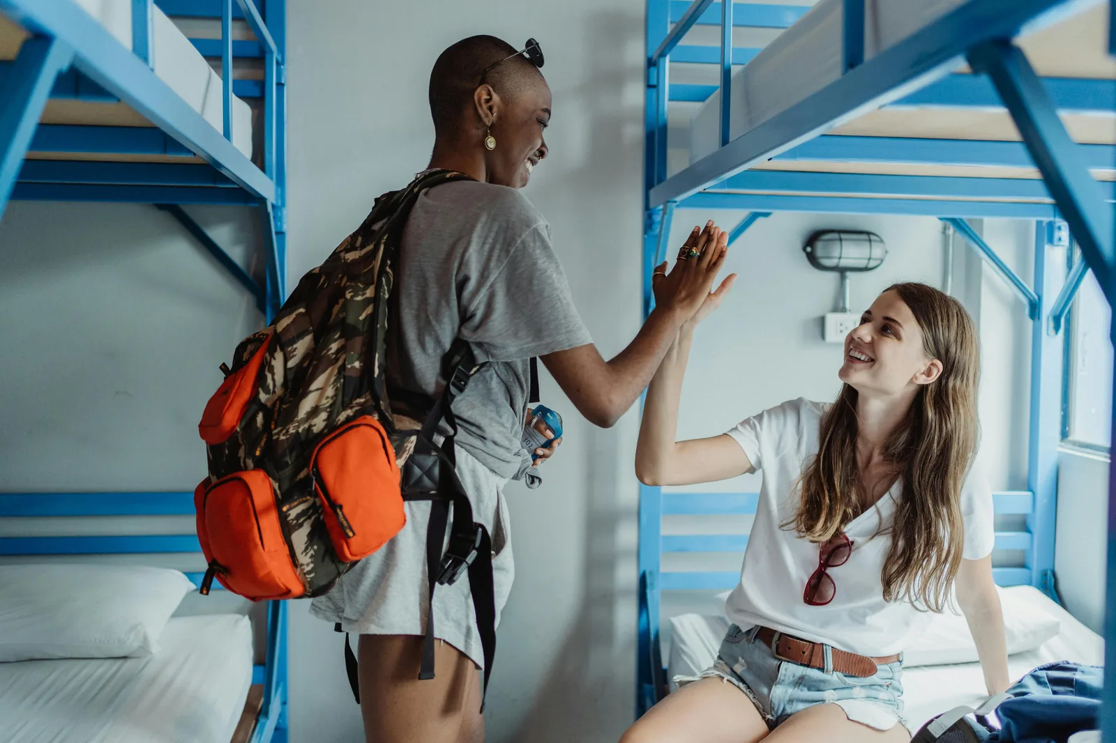 A bright, modern hostel common room in Melbourne with backpackers socialising