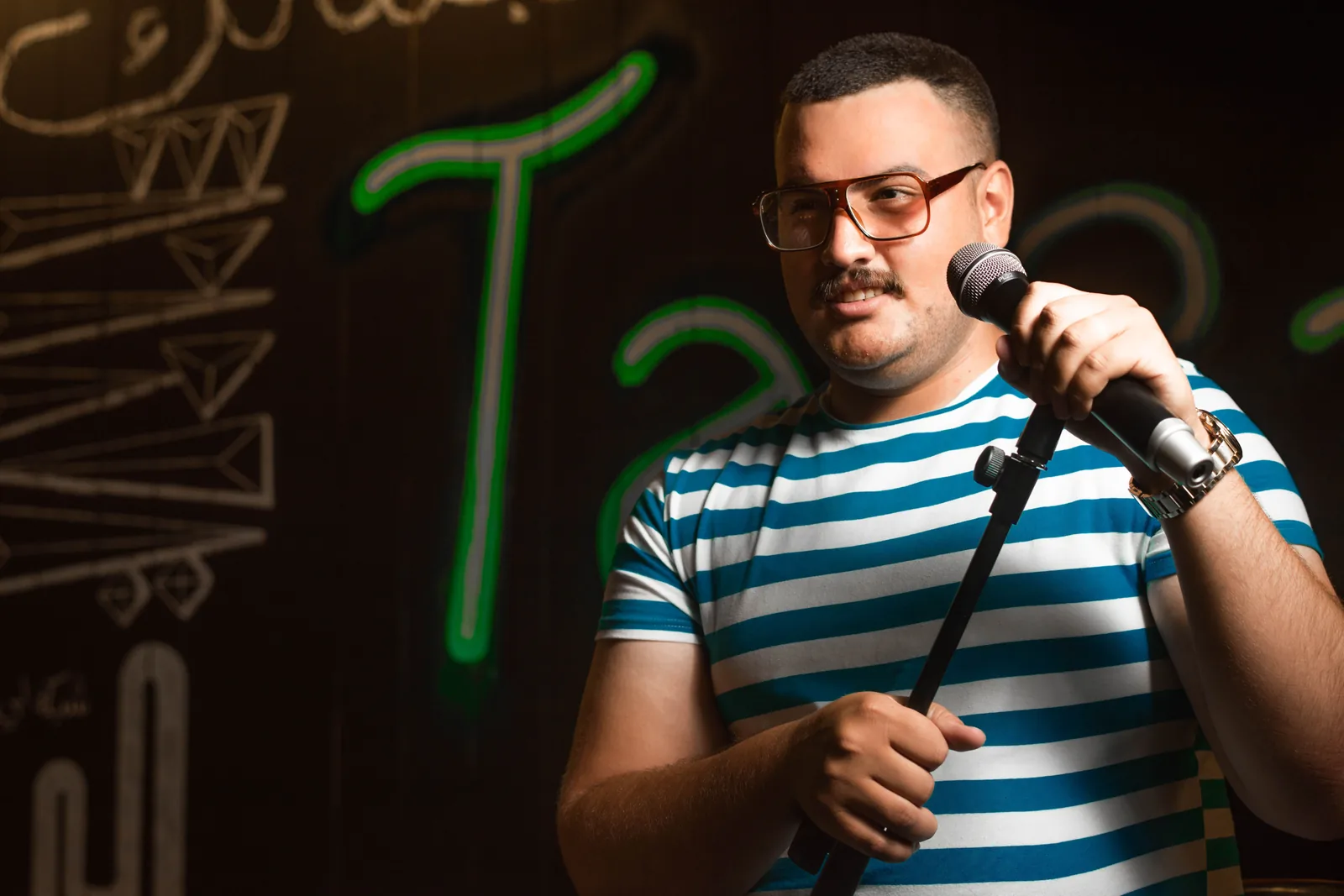 A stand-up comedian performing on stage in a Melbourne comedy club