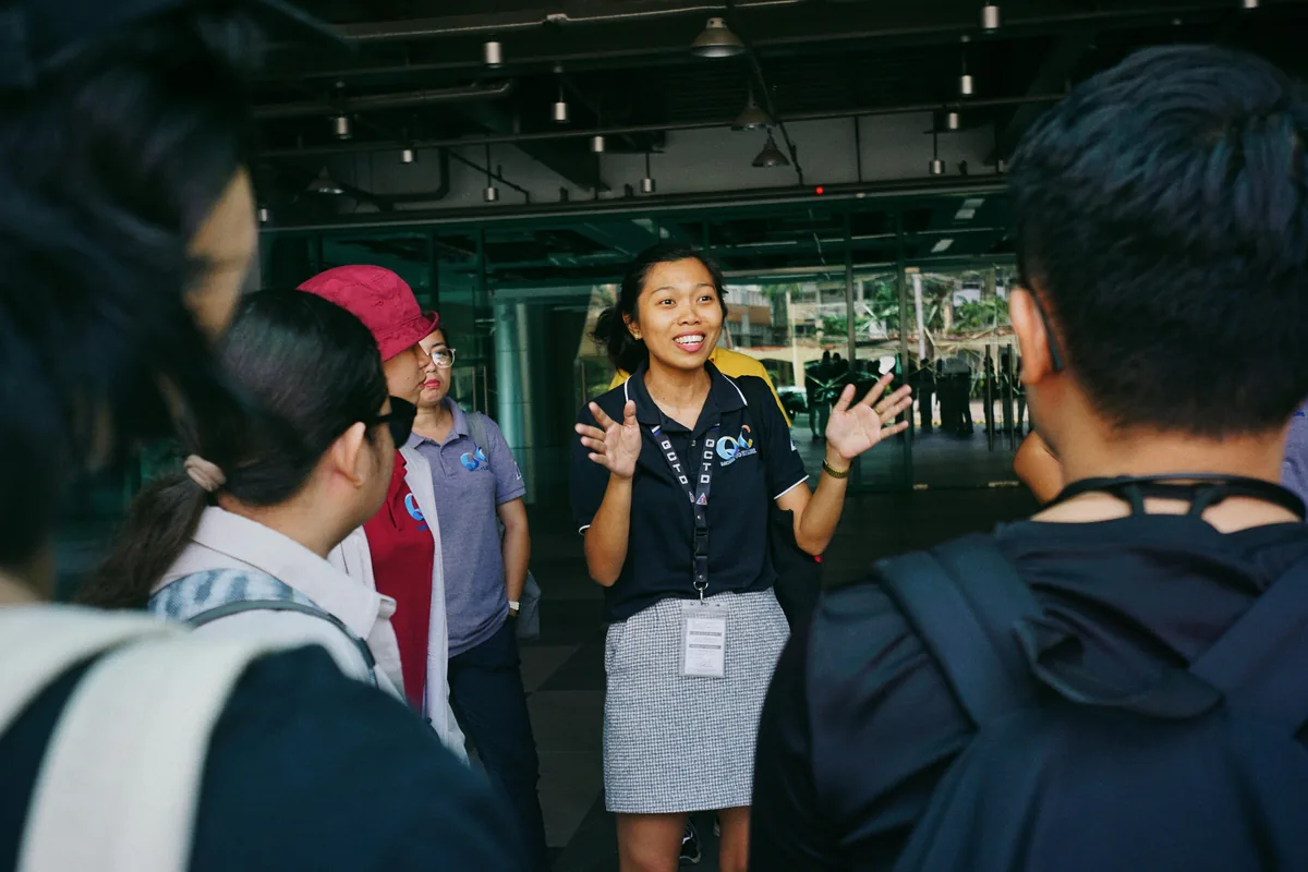 A tour guide pointing out a Melbourne landmark to visitors