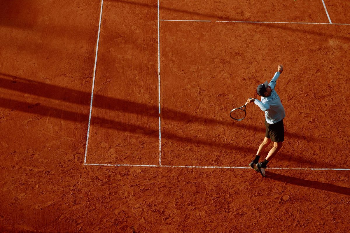 A tennis player serving on court