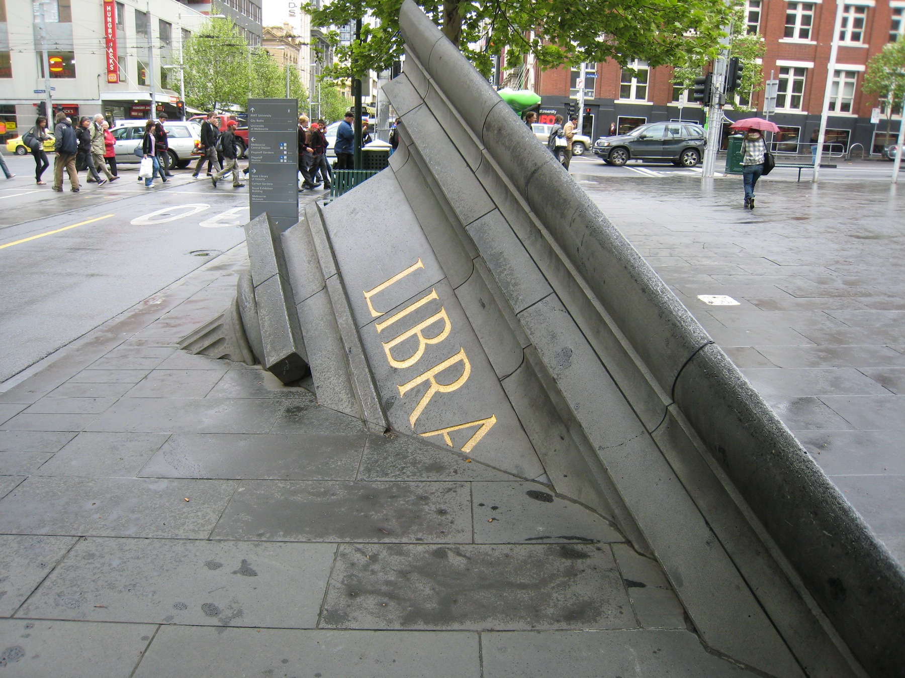 Architectural Fragment sculpture by Petrus Spronk sinking into the footpath outside State Library Victoria