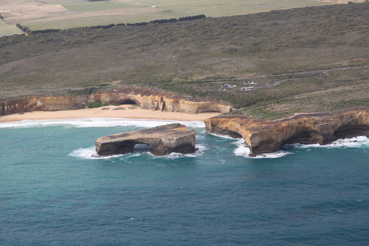 Aerial view of London Arch, a detached limestone arch standing in turquoise water off the cliffs near Port Campbell