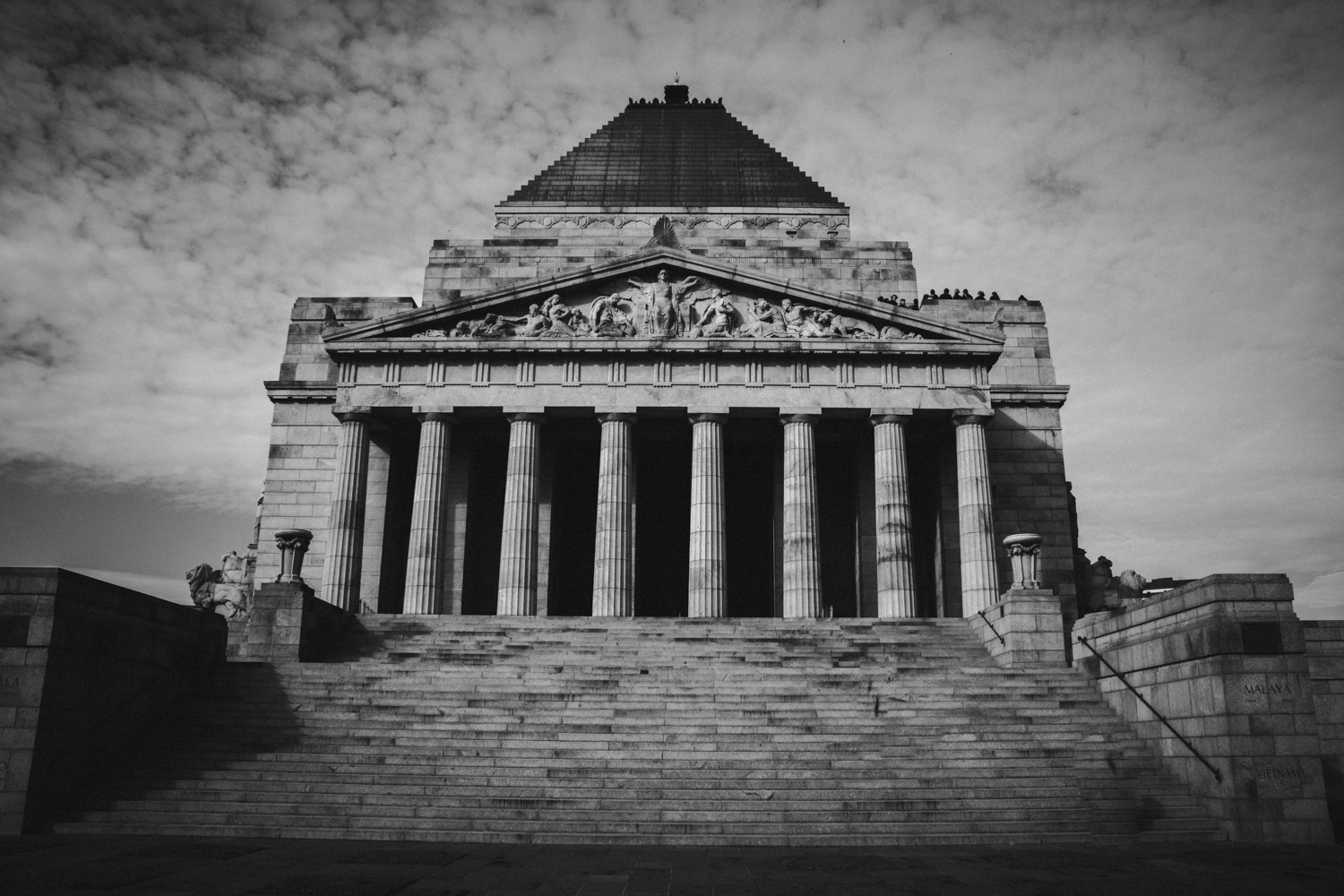 The Shrine of Remembrance in black and white, with its stepped pyramid roof, Doric columns and wide stone staircase